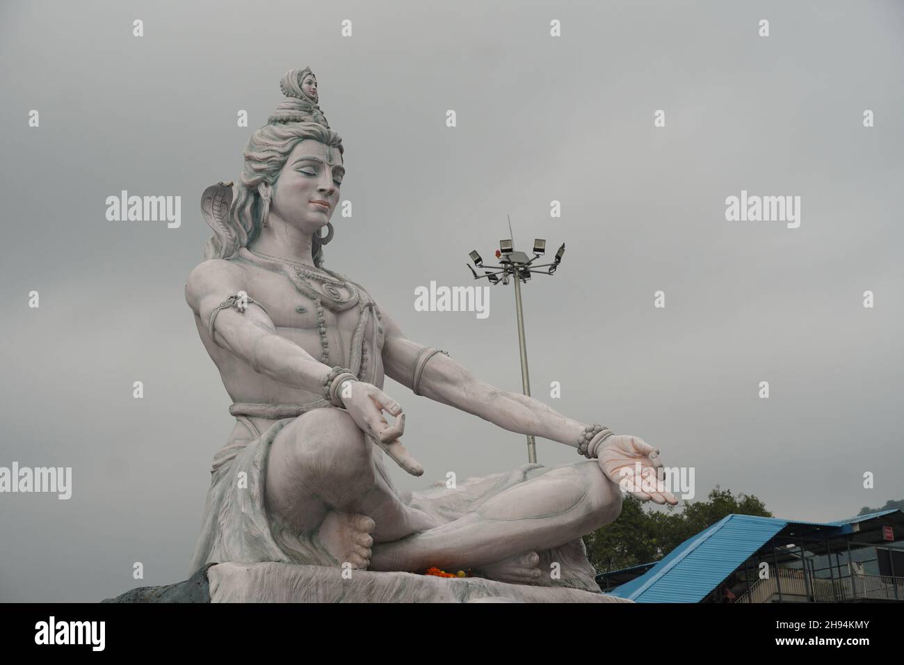 Hindu god Shiva sculpture sitting in meditation on Ganges river in Rishikesh, India, Stock Photo