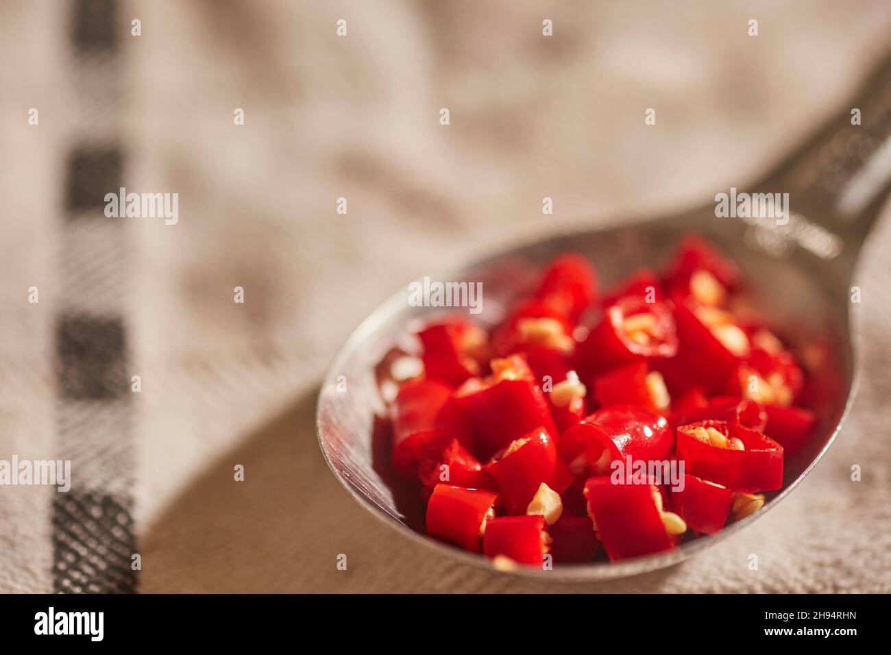 A tablespoon of chopped, fresh, Thai red chili peppers Stock Photo