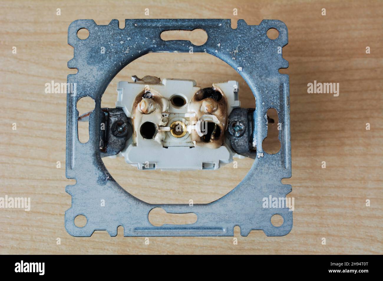 Broken power overload switch electric outlet. Electric short circuit causing fire on plug socket. Stock Photo