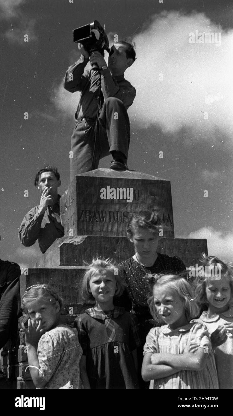 Warszawa, 1947-07-17. Pogrzeb gen. Lucjana ¯eligowskiego na Cmentarzu Wojskowym na Pow¹zkach. Nz. operator W³adys³aw Forbert z Przedsiêbiorstwa Pañstwowego Film Polski i dzieci (gapie).  bk/gr  PAP      Warsaw, July 17, 1947. State funeral for General Lucjan Zeligowski on Powazki Military Cemetery. Pictured: cameraman Wladyslaw Forbert of Film Polski and children (spectators).   bk/gr  PAP Stock Photo