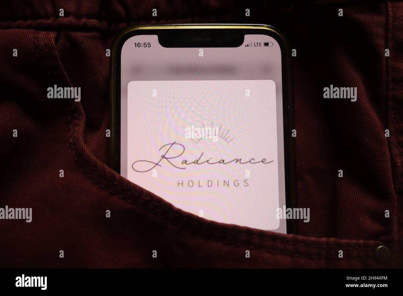 KONSKIE, POLAND - September 15, 2021: Radiance Holdings logo displayed on mobile phone hidden in jeans pocket Stock Photo