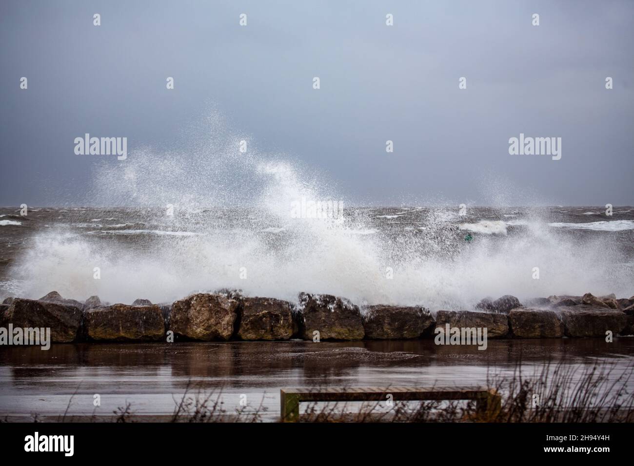 Heysham, Lancashire, UK. 4th Dec, 2021. Stron WInds brought over topping at high tide on the promenade at Heysham Credit: PN News/Alamy Live News Stock Photo
