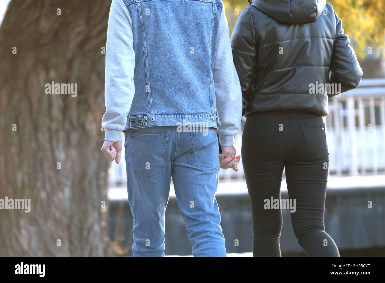 Back view of young couple walking on city street enjoying time together ...