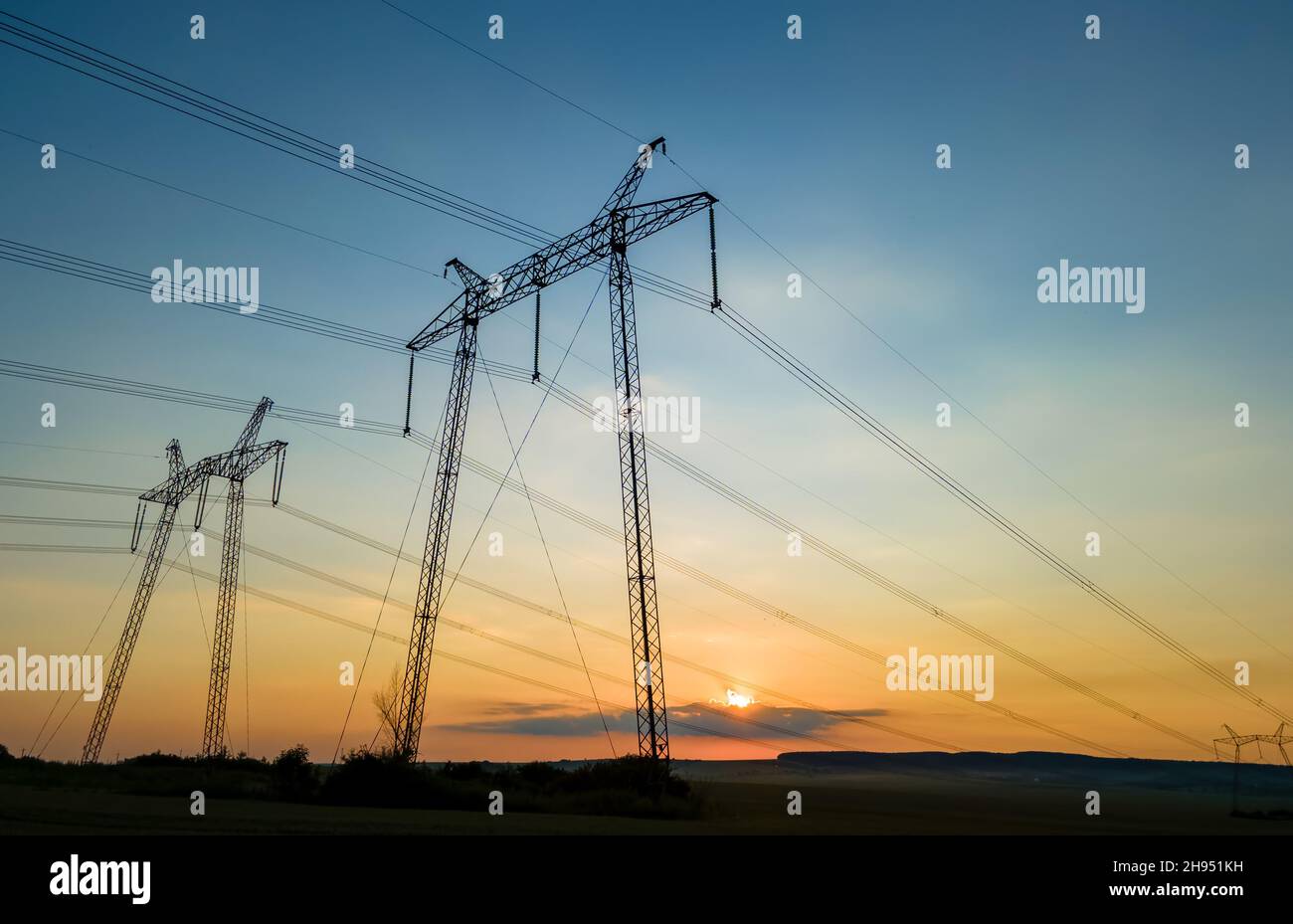High voltage towers with electric power lines at sunset Stock Photo - Alamy