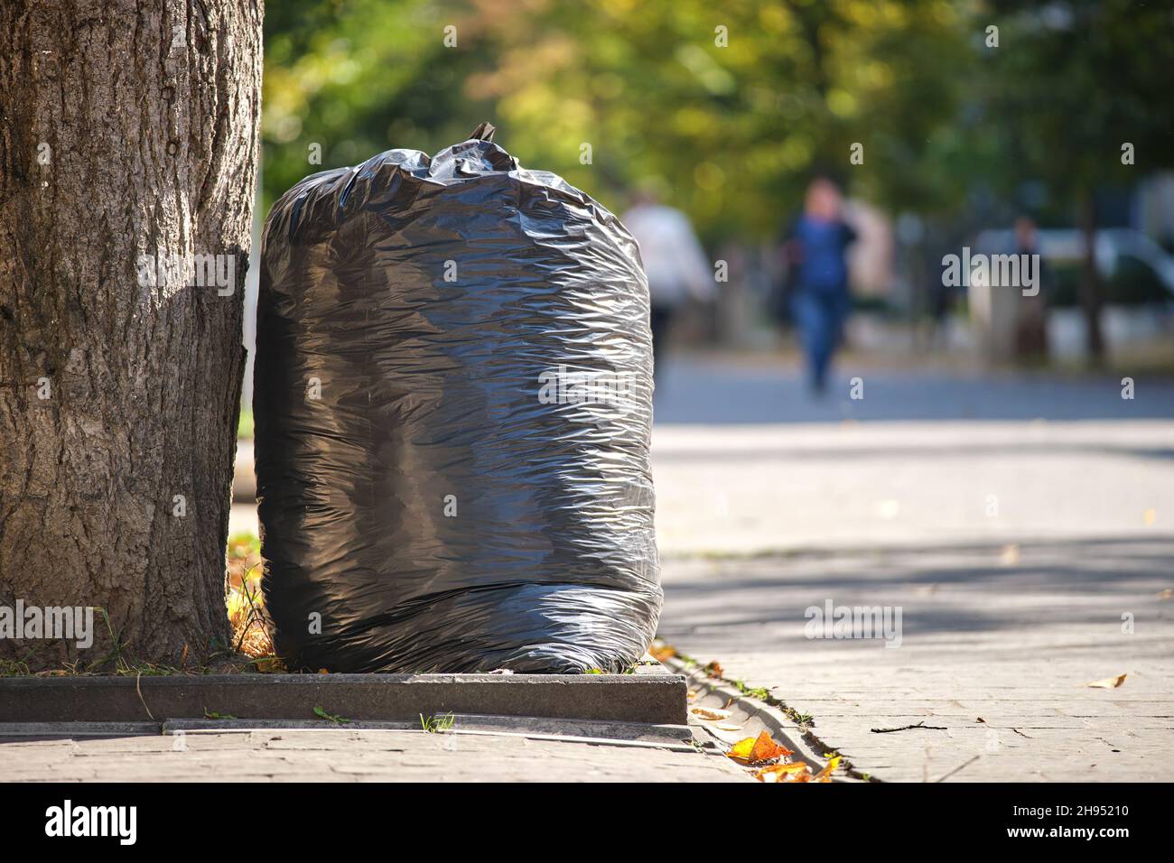 Pile of black garbage bags full of litter left for pick up on street