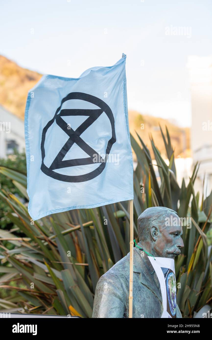 Great Malvern, Worcestershire, UK. 4th Dec, 2021. An Extinction Rebellion flag is attached to the bronze statue of Sir Edward Elgar in Bell Vue Terrace Island, Great Malvern, Worcestershire. The famous English composer is an unwitting supporter of the climate activists XR Malvern aims, as his statue bears the XR flag and a poster which reads 'grief and love for the Earth'. Credit: Peter Lopeman/Alamy Live News Stock Photo