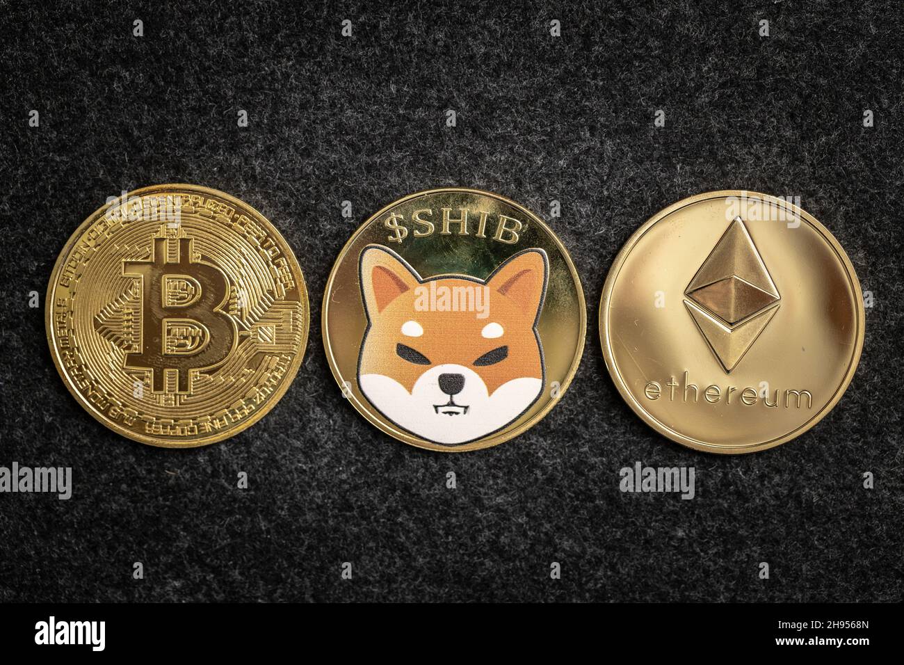 Shiba Inu Coin between Bitcoin and Ethereum physical coins Stock Photo