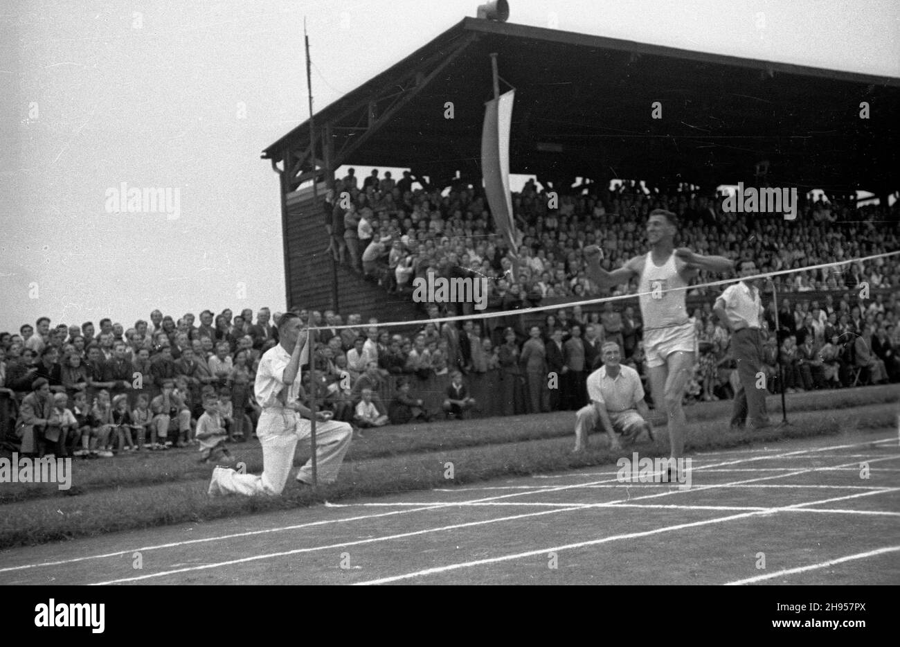 Katowice, 1947-07-27. Miêdzynarodowe Zawody Lekkoatletyczne na stadionie Pogoni. Nz. reprezentant Stanów Zjednoczonych Irving Mondschein na finiszu jednej z konkurencji biegowych. wb/gr PAP Katowice, July 27, 1947. An international track-and-field meet in Pogon Stadium. Pictured: Irving Mondschein from the U.S. passes the finishing line. wb/gr PAP Stock Photo