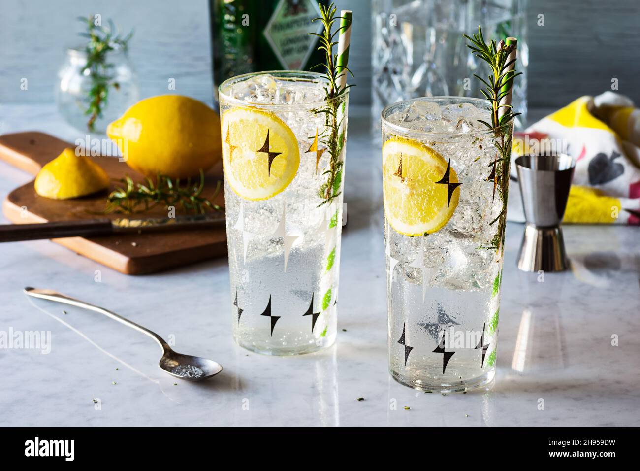 Rosemary Lemon Gin Fizz Cocktail Drinks over Ice on Marble Bar Top with Ingredients Stock Photo