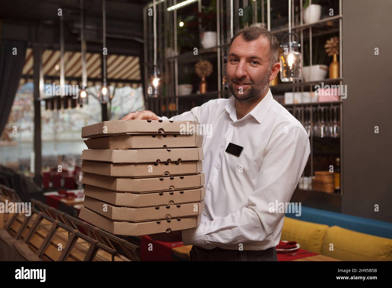 Waiter Box Male waiter holding many pizza boxes, walking through the restaurant ...