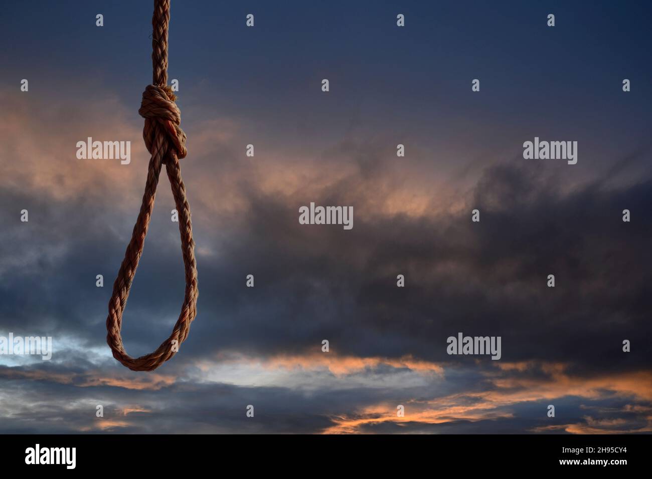Rope noose on dramatic blue sky. Space for text Stock Photo