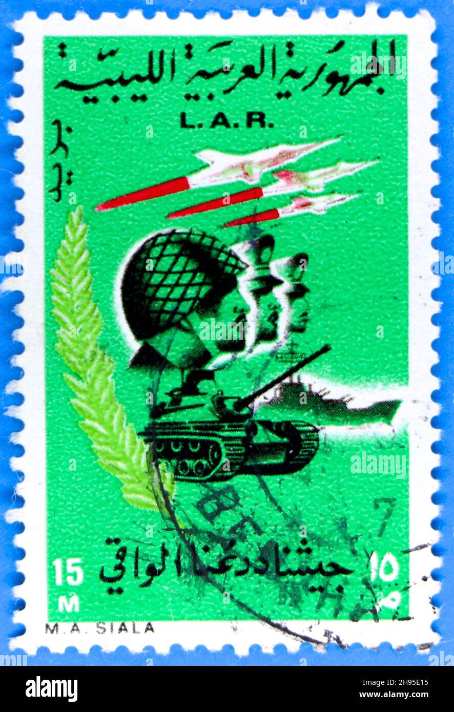 Photo of a green Libyan Arab Republic postage stamp featuring military graphics to celebrate the revolution in 1969 Stock Photo