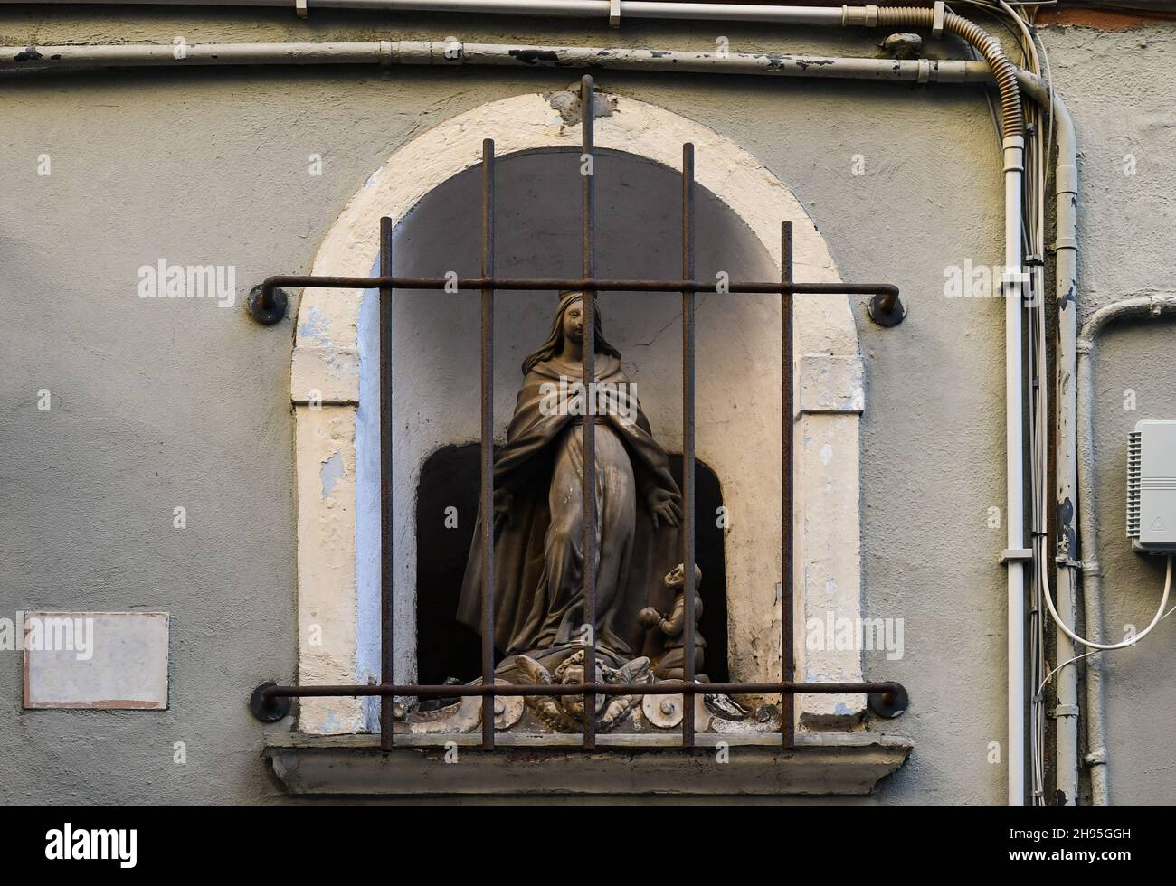 Close-up of a votive shrine on the facade of an old building in Via San Vincenzo street, Genoa, Liguria, Italy Stock Photo