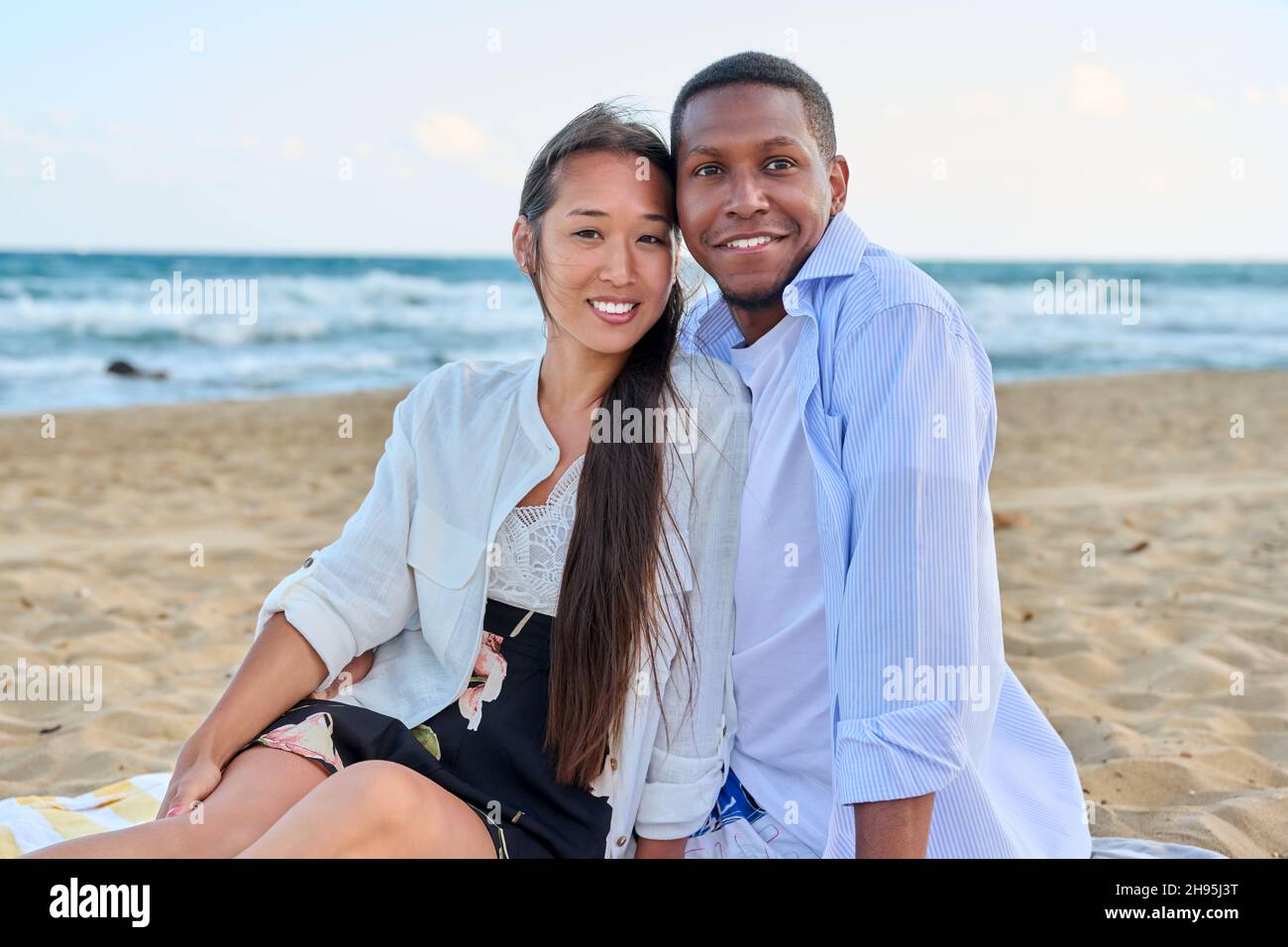 Happy multiethnic family having a rest on the beach together Stock Photo