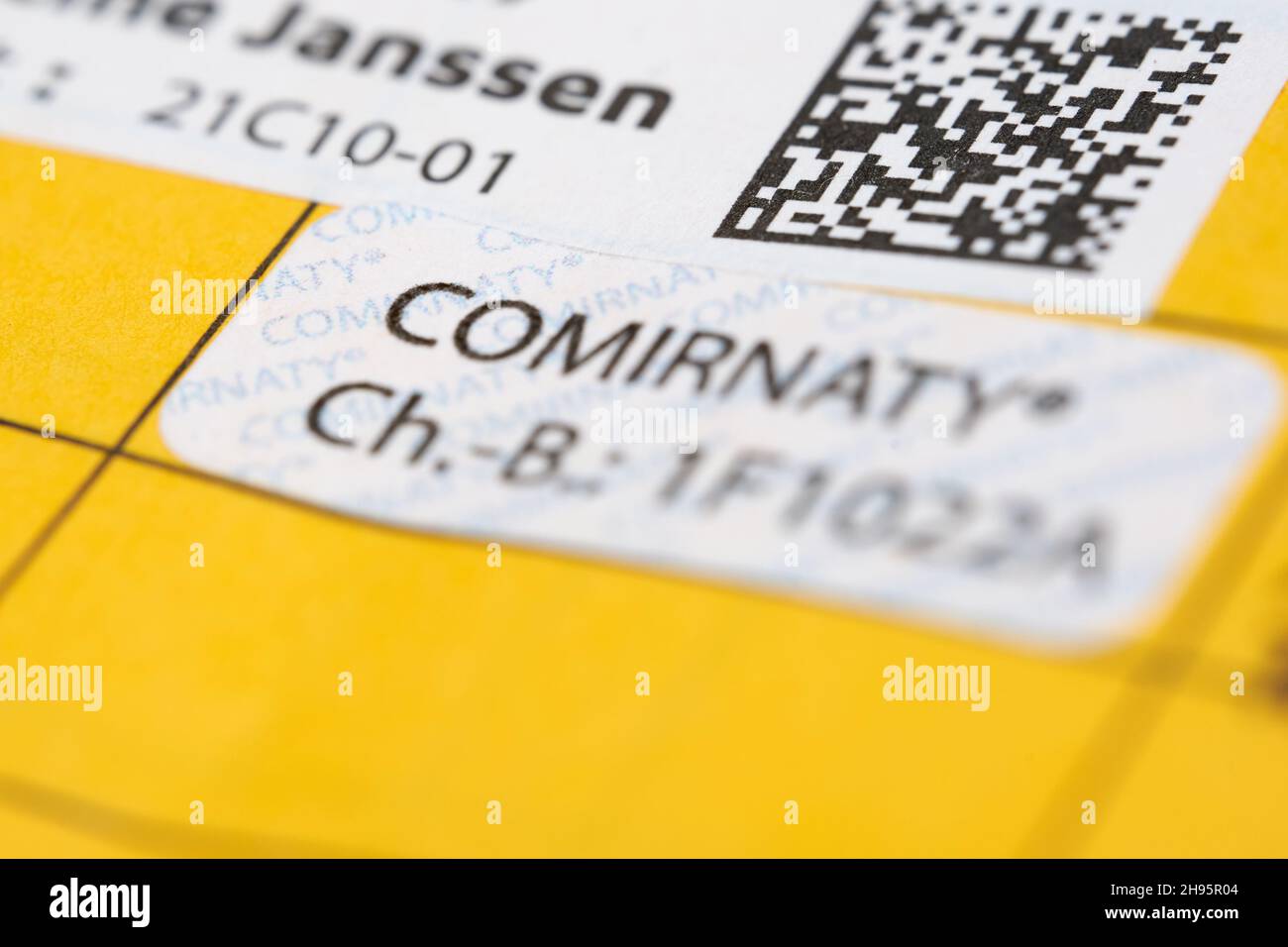 Stuttgart, Germany - December - 04, 2021: Booster vaccination against Corona covid-19 virus. Yellow vaccination card with proof label. Vaccine from Bi Stock Photo