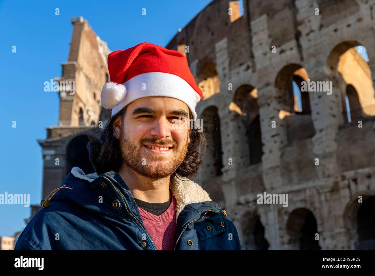 Beautiful man traveling to Rome. The young man wears Santa's hat and ...
