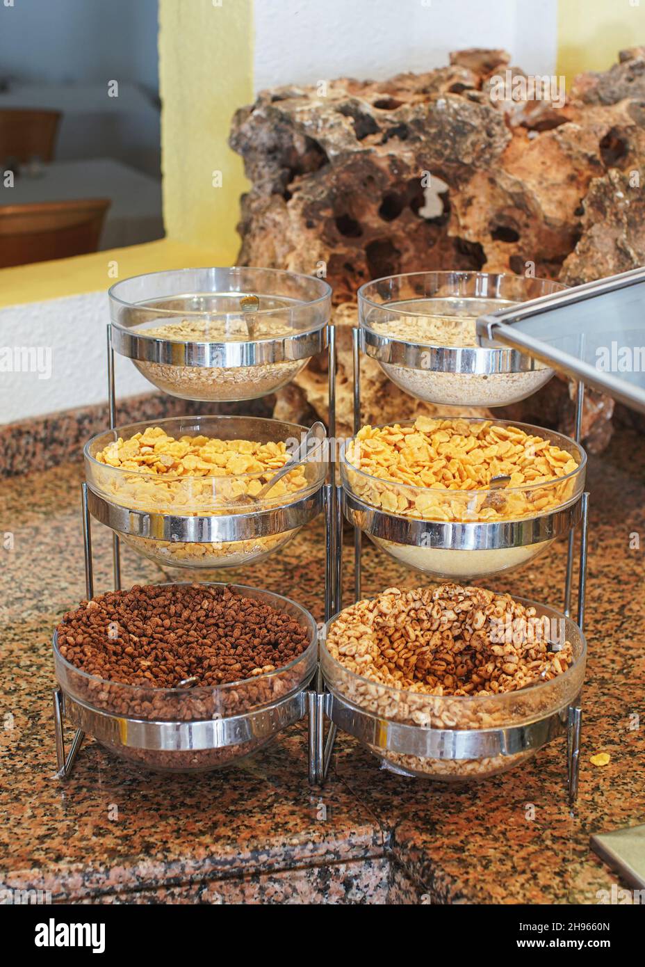 Corn, cereals and rice flakes in glass bowls displayed at restaurant breakfast buffet table Stock Photo