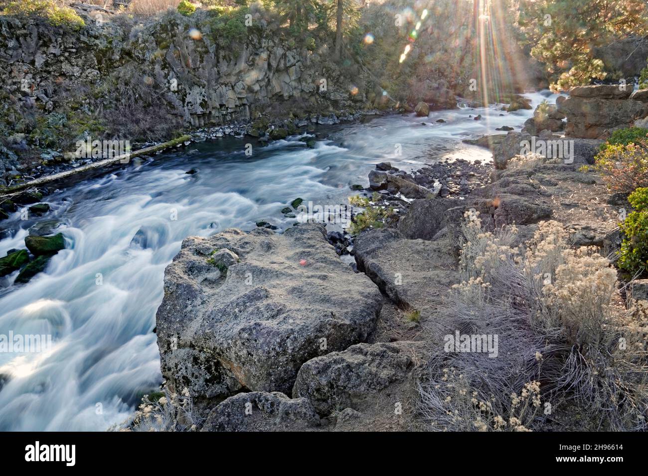 A section of  Dillon Falls lit by a sun flare on the Deschutes River in central Oregon near the city of Bend. Stock Photo