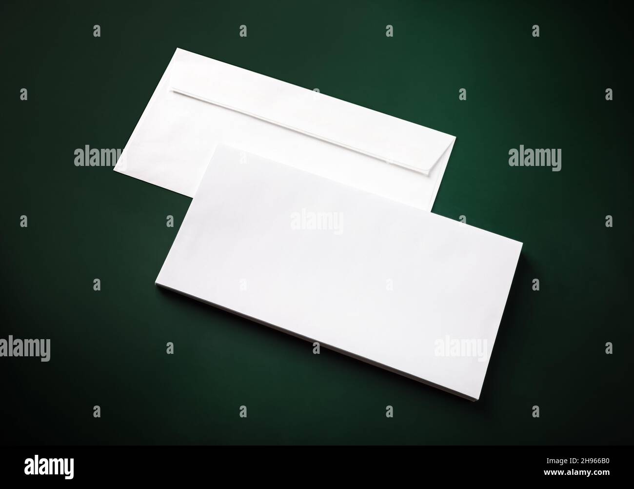 Two blank white envelopes on green background. Copy space. Stock Photo