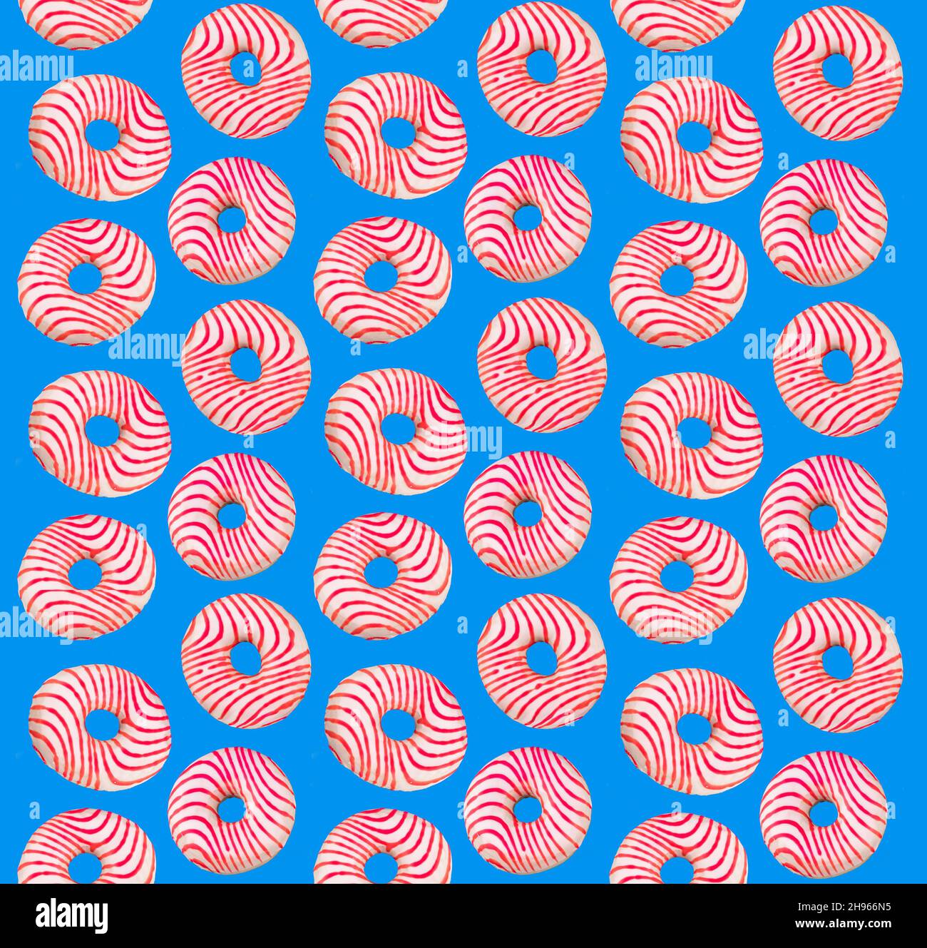 Flat lay donuts pattern on a blue background. Top view. Pink and white ...