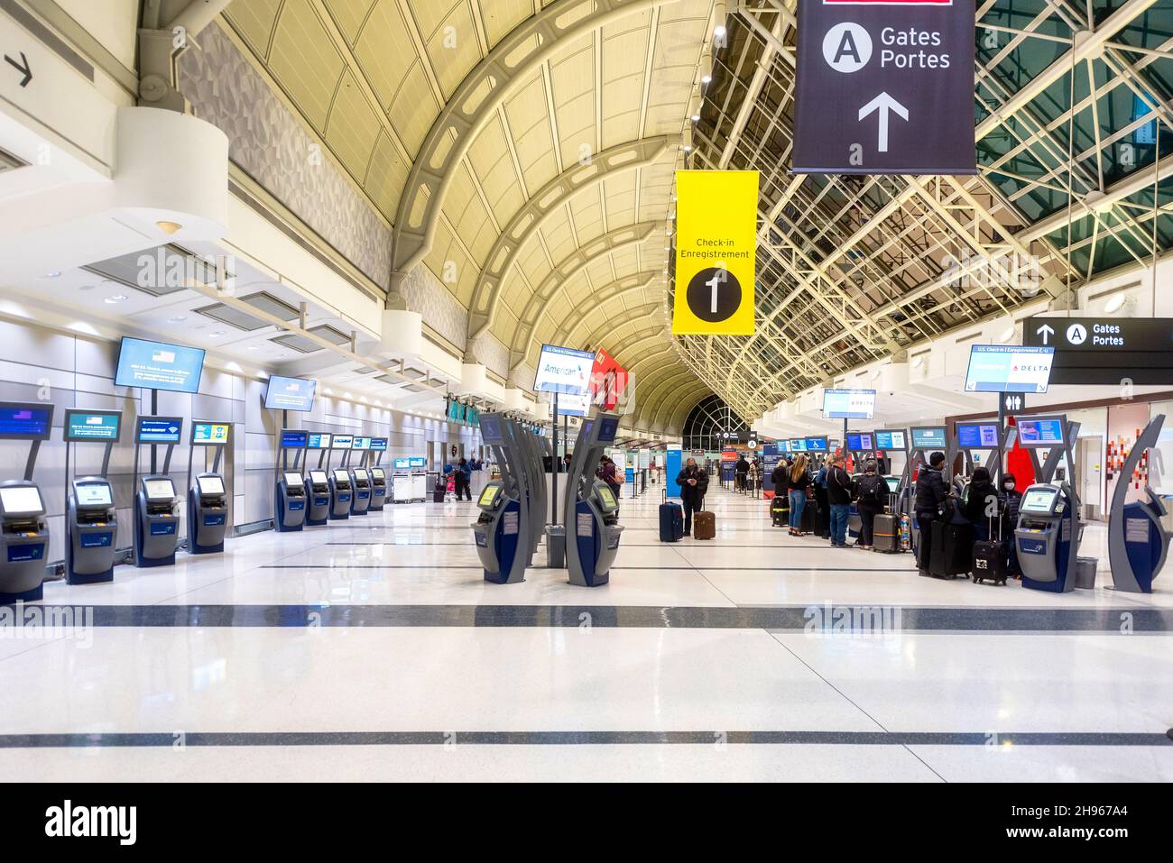 Passengers at self check-in machines and the Interior architecture of the Terminal 3 at Pearson International Airport. Dec. 4, 2021 Stock Photo