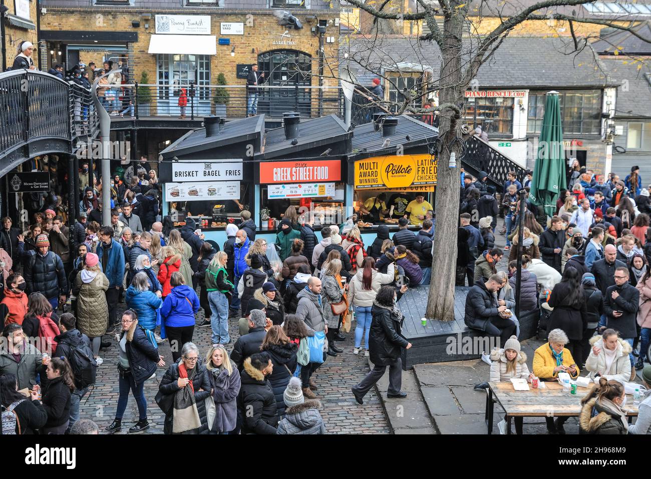 London, UK. 4th Dec, 2021. Camden High Street and Camden Market are busy, with visitors and shoppers crowding into shops, indoor and outdoor food outlets and along the stalls, with little visible mitigation to practice social distancing so far and indoor mask wearing apparently not strictly enfornced. Credit: Imageplotter/Alamy Live News Stock Photo