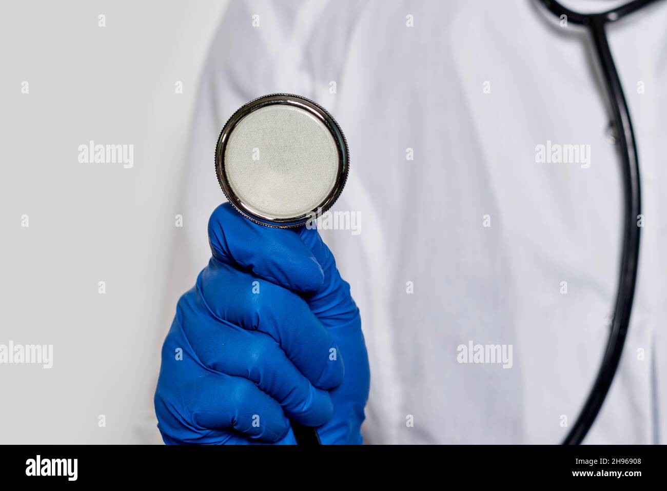 A doctor with stethoscope. Female doctor with a stethoscope in the hands. Doctor using stethoscope in hospital Stock Photo