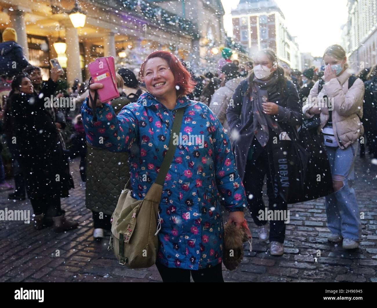 Artificial snow is sprayed in the air as people visit Covent Garden