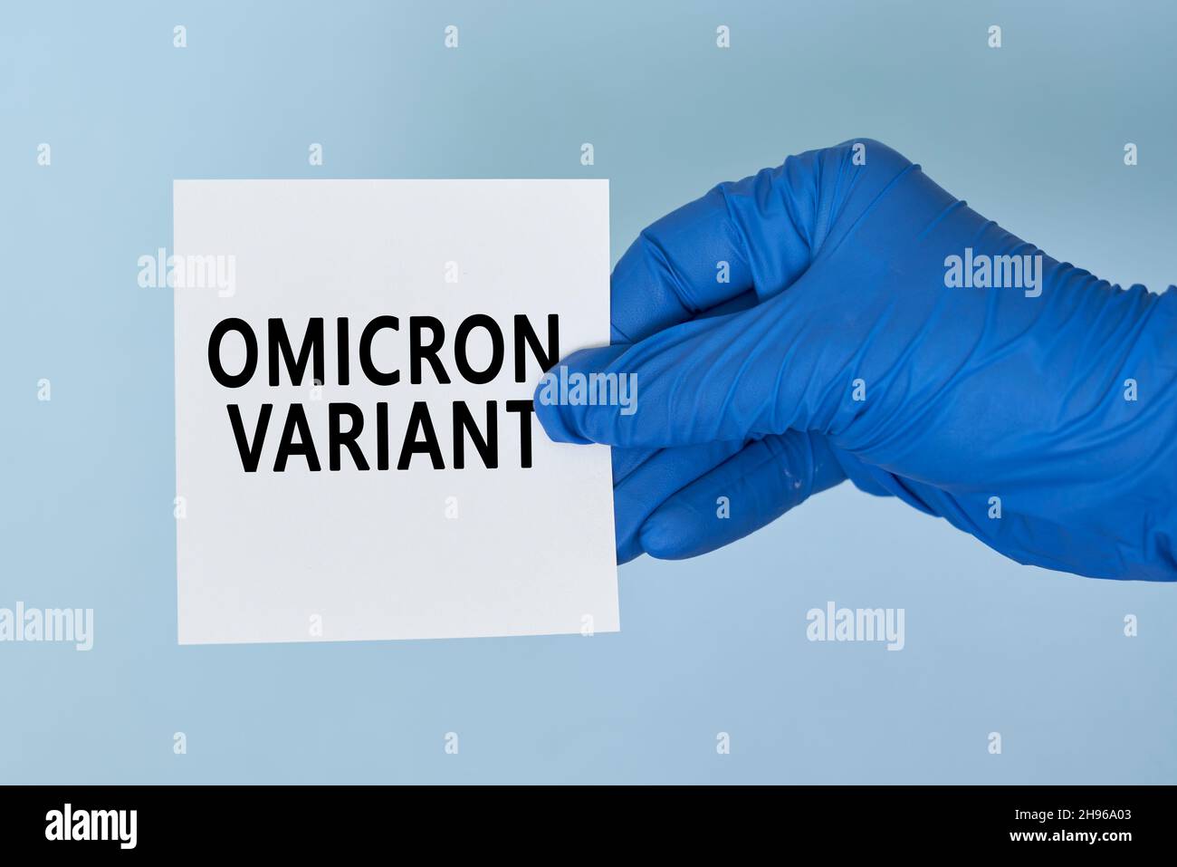 Doctor hand holds a card with text - New covid variant Omicron. Covid-19 new variant - Omicron. Omicron variant of coronavirus. SARS-CoV-2 variant of Stock Photo