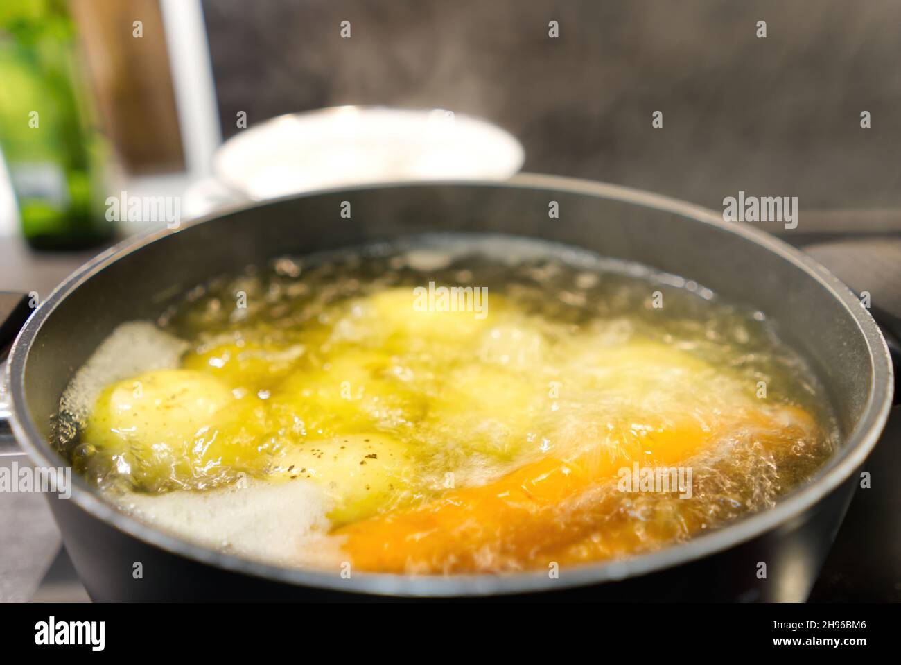 Pot of boiling water in which potatoes and carrots are boiled Stock