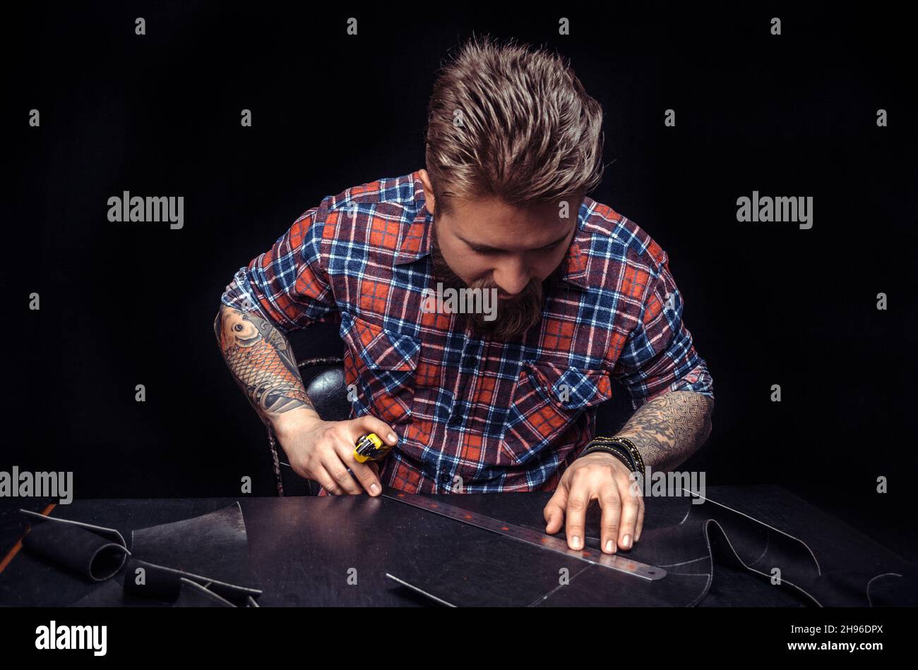Worker of leather producing leather workpiece Stock Photo