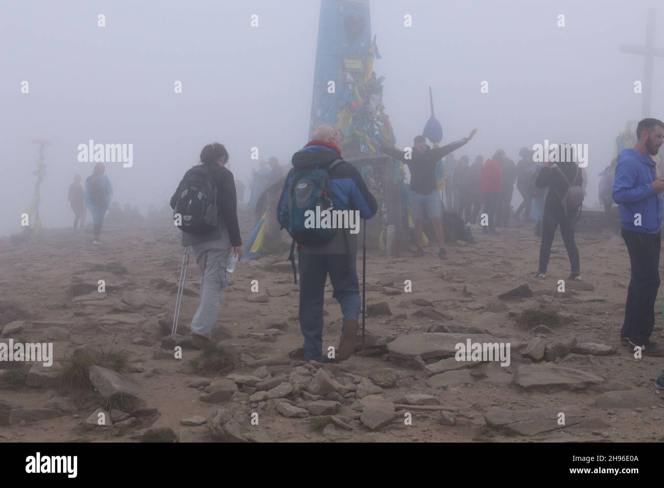 Peak Hoverla/Ukraine -  Tourists with children climb to the top of the mountain in heavy fog. The top of the mountain is covered with clouds Stock Photo