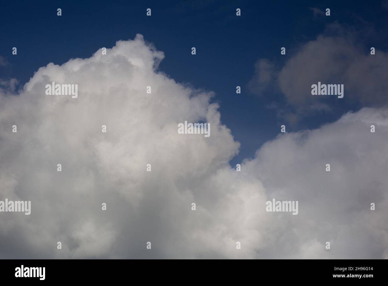 Cloudscape with fluffy white clouds against a deep blue sky Stock Photo
