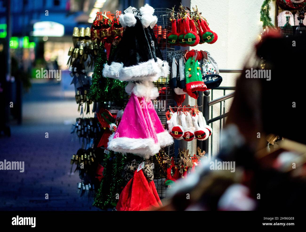 Delmenhorst, Germany. 04th Dec, 2021. Various Christmas items, including numerous Christmas hats, are for sale in front of a downtown store. The Christmas business in the inner cities of Lower Saxony is threatened by a severe Corona dent again this year. Credit: Hauke-Christian Dittrich/dpa/Alamy Live News Stock Photo