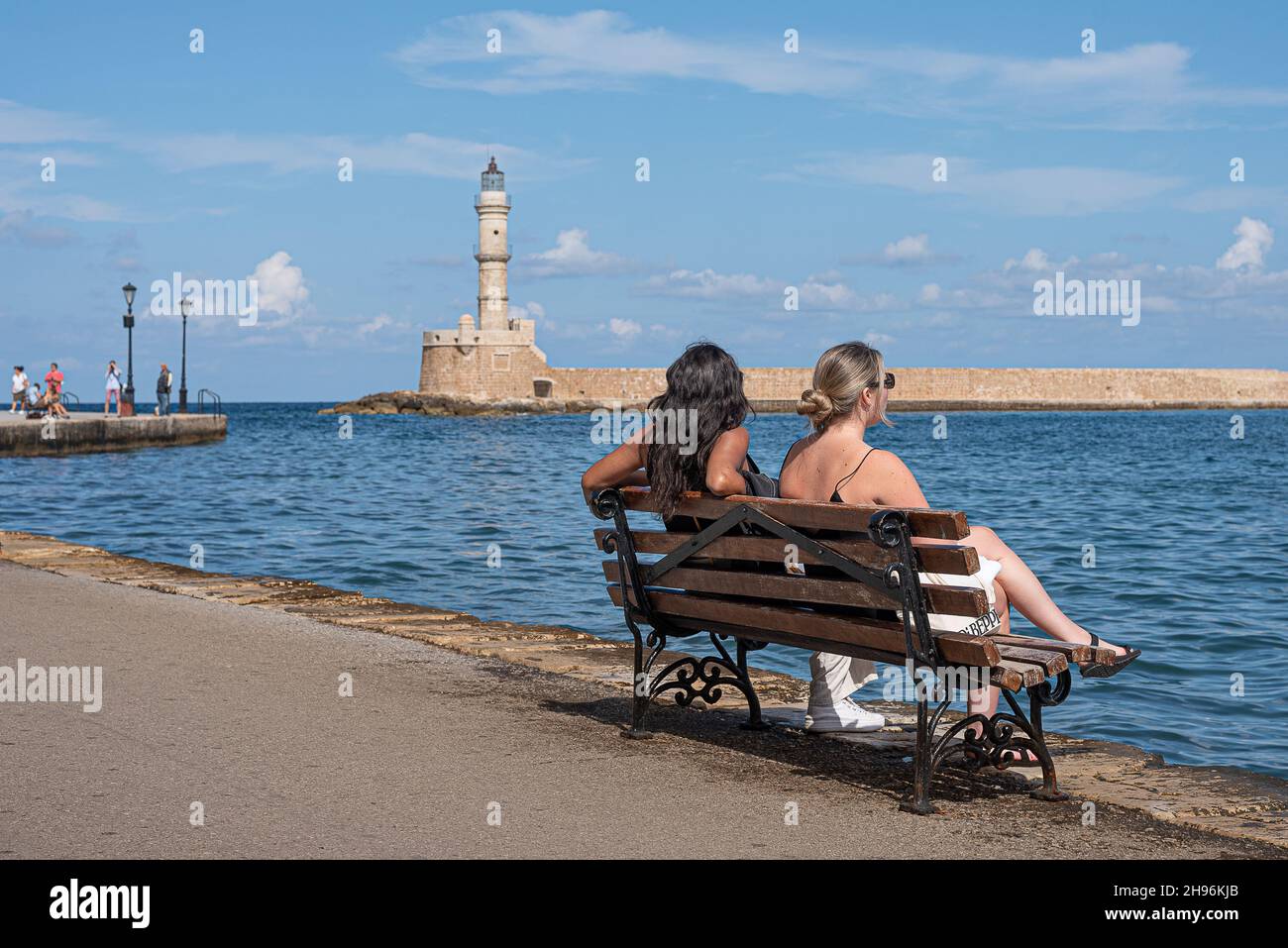 Two women sitting on a bench in the venetian harbour of Chania, Crete, Greece, October 18, 2021 Stock Photo