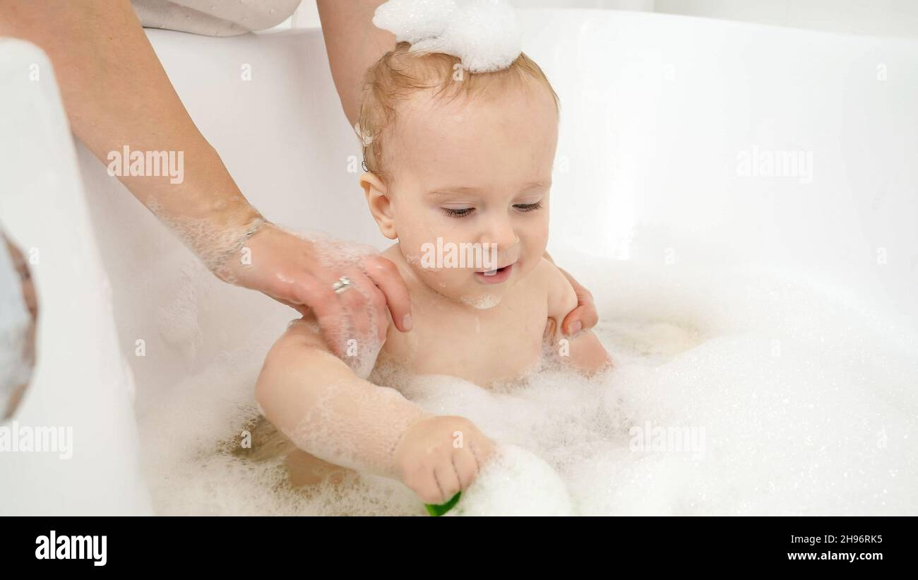 Cute baby boy covered in soap foam washing in bathroom Stock Photo Alamy
