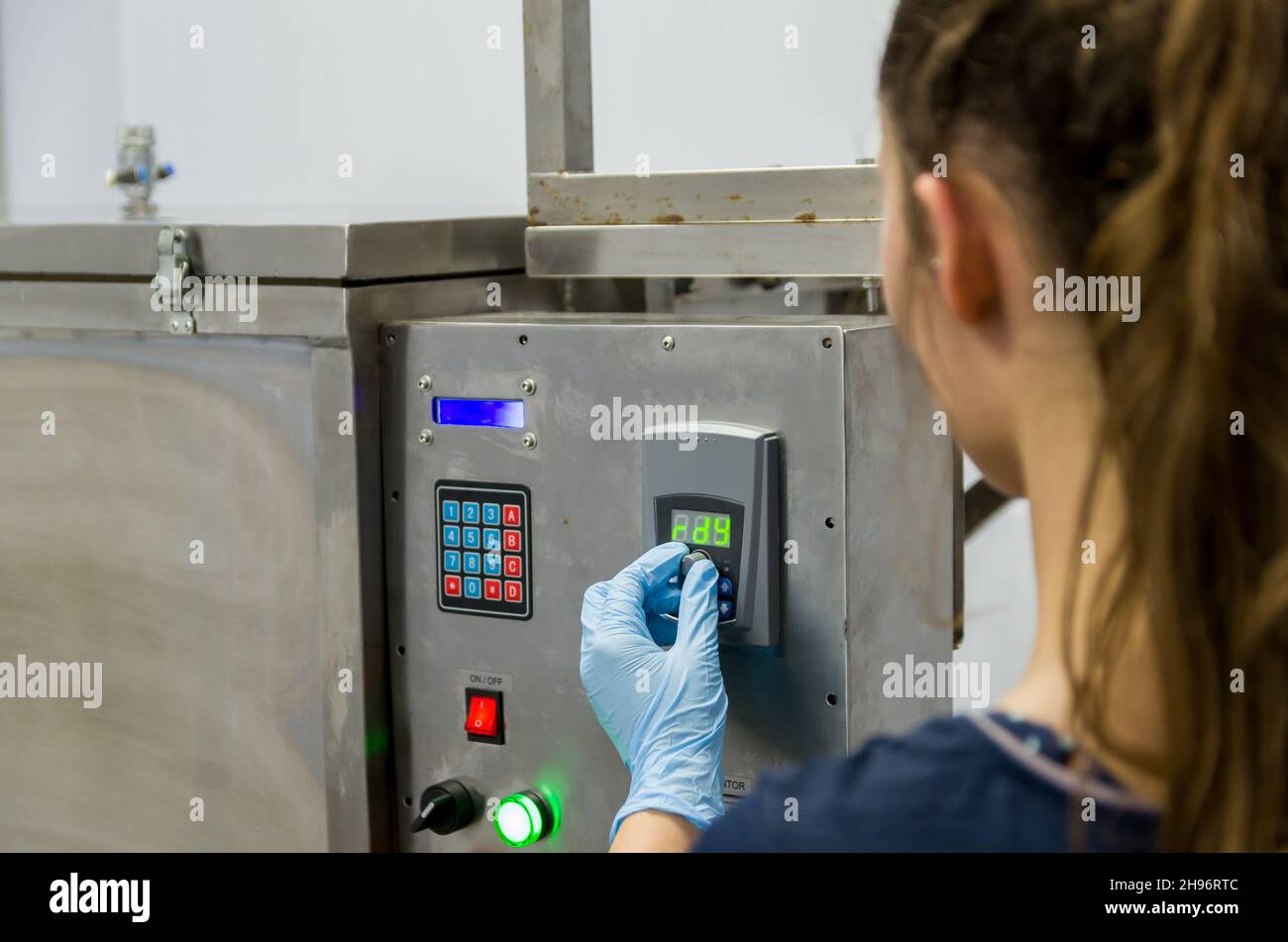 Woman working in industry, adjusting equipament Stock Photo