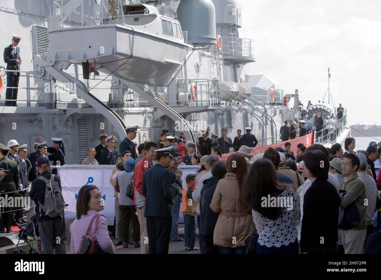 Chinese sailors welcome the public onboard The Peoples Liberation Army Navy Ship’s HAERBIN (DDG112), a LUHU Destroyer, from China visiting Auckland, New Zealand on Sunday 7 October 2007. Stock Photo