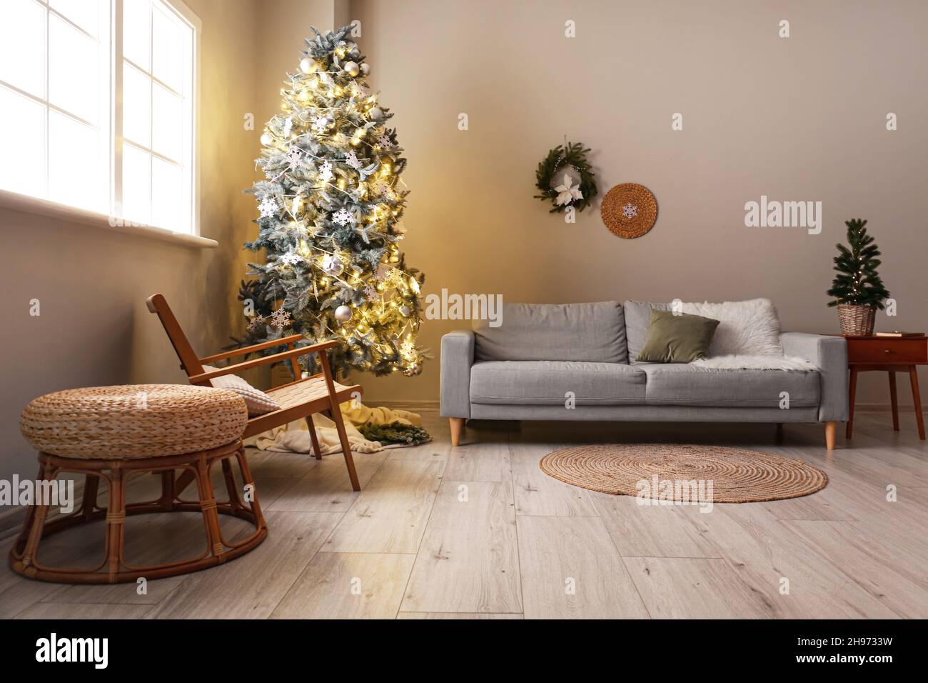 Interior of modern living room with beautiful Christmas tree, armchair ...