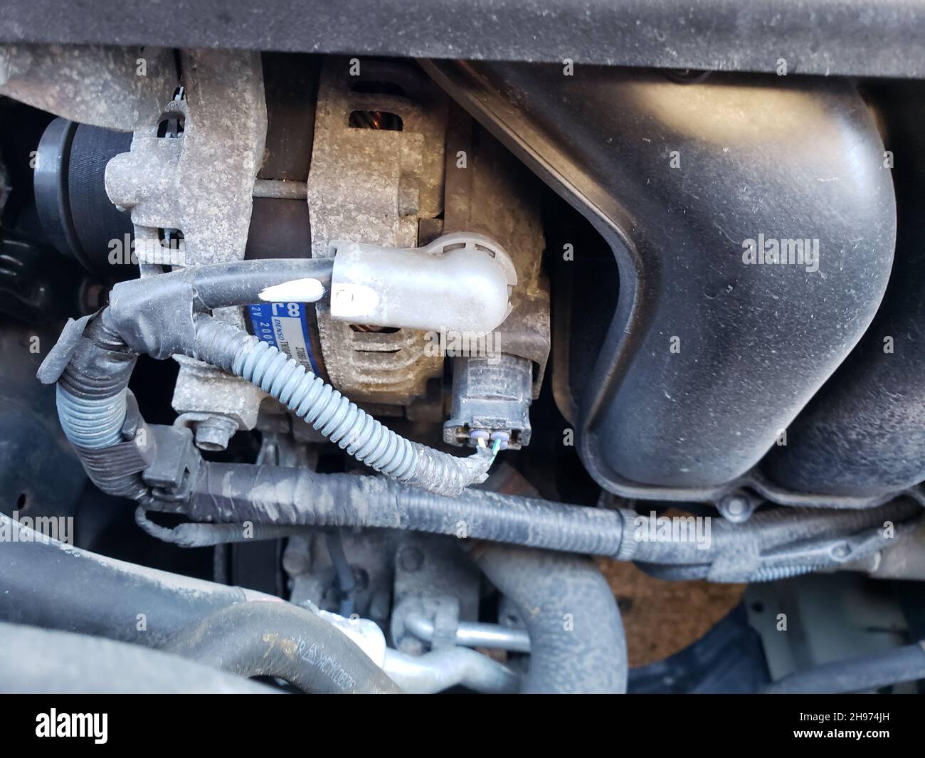Old Alternator seen inside an engine of a Toyota Corolla Stock Photo