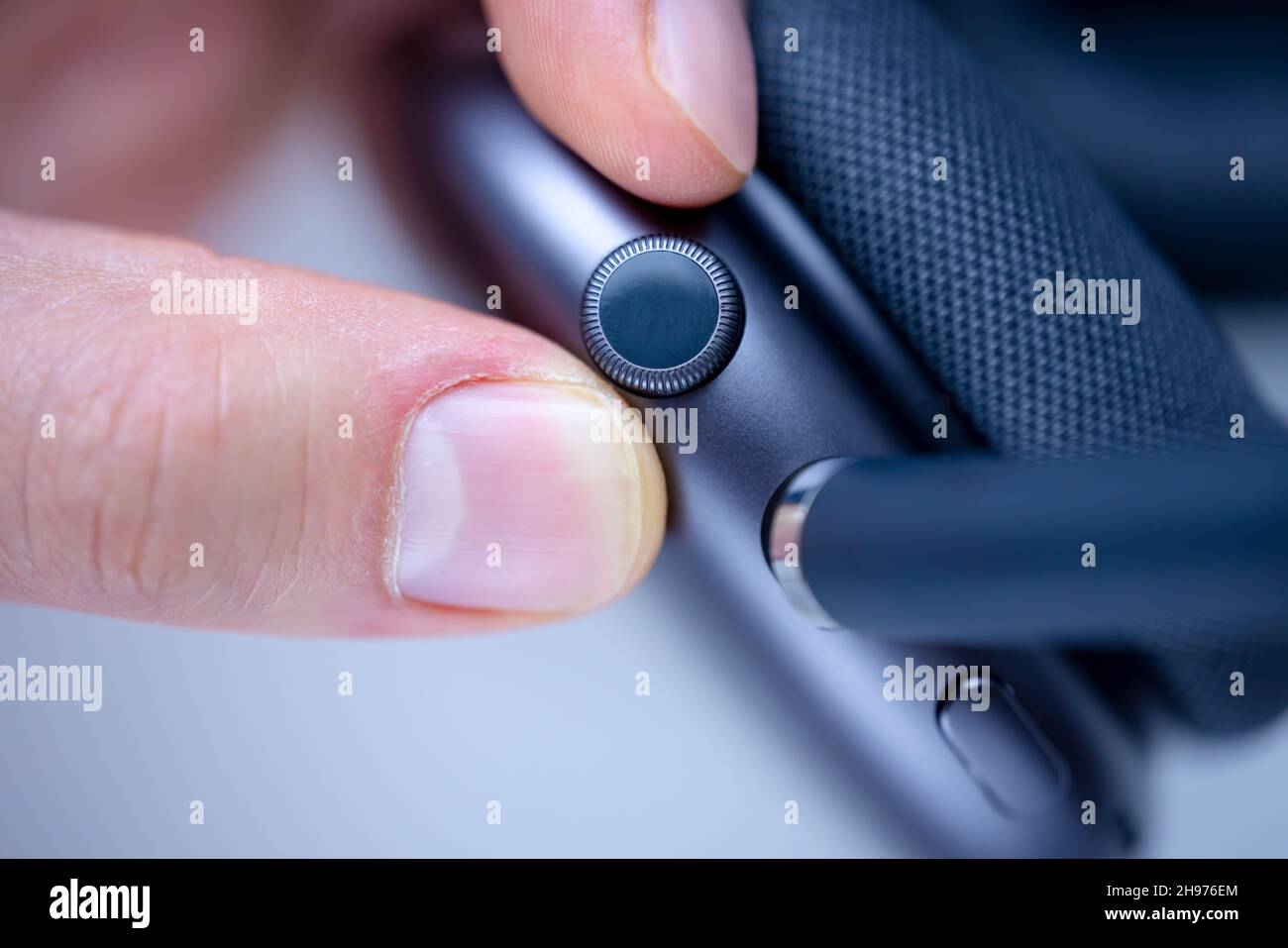 A Close up of a person controlling a Digital Crown set of AirPods Max,  space grey color Stock Photo - Alamy