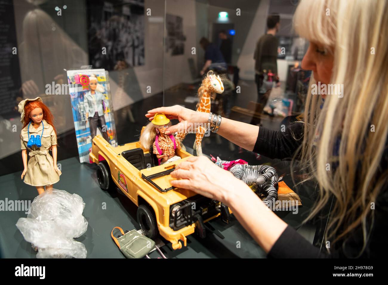 Tactiel gevoel leeuwerik Gorgelen 03 December 2021, Lower Saxony, Emden: Bettina Dorfmann, Barbie doll  collector, sets up the exhibition "Busy girl - Barbie makes a career" at  the Ostfriesisches Landesmuseum. In the background hangs a photo