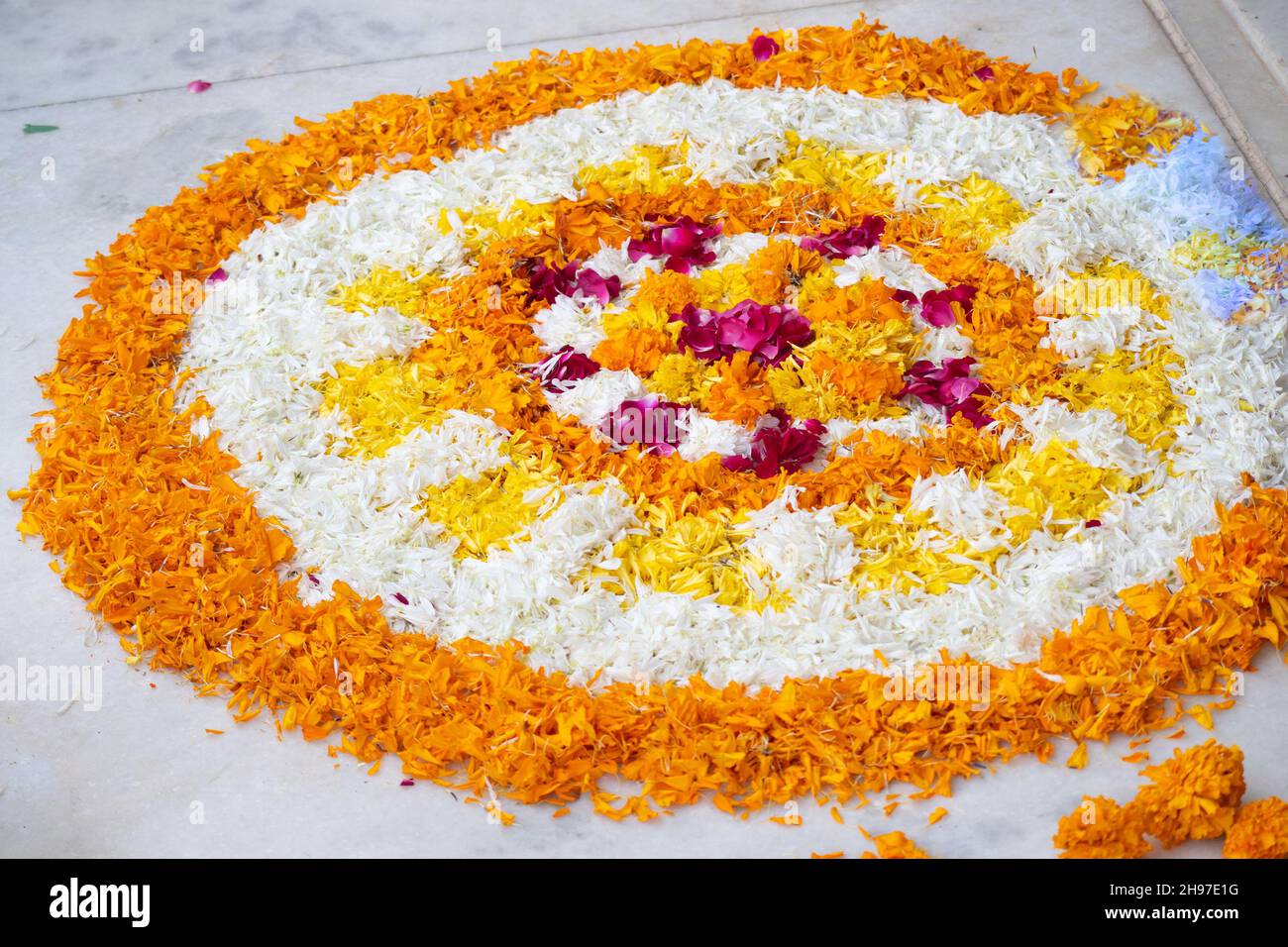 Rangoli pookalam pattern made of flower petals on teh ground for religious celebrations like diwali, christmas and new year Stock Photo
