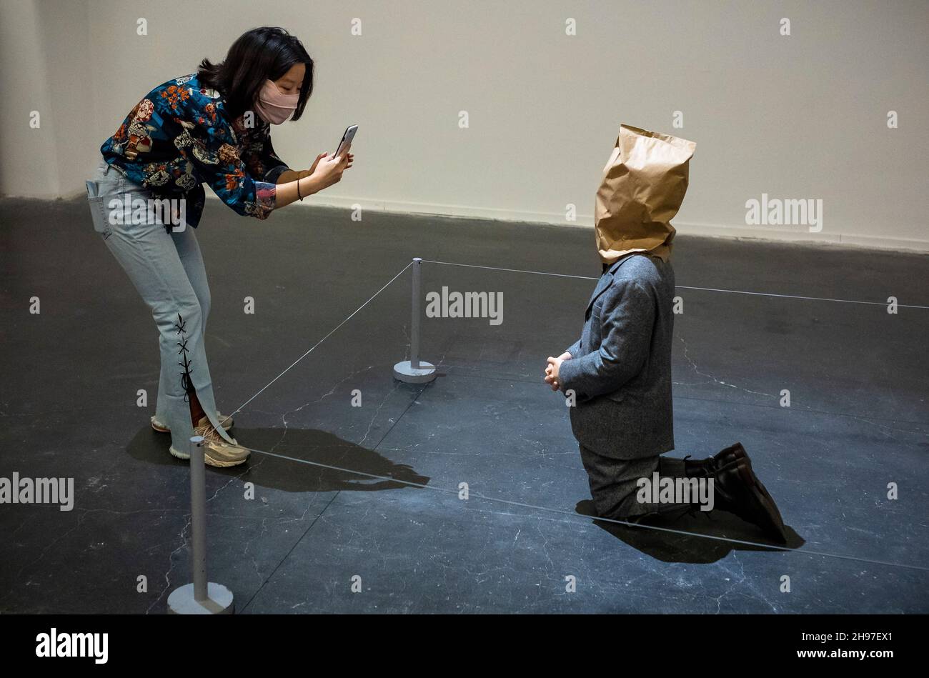 Beijing, China. 05th Dec, 2021. Kneeling man with a paper bag on his head at Maurizio Cattelan ‚The Last Judgment' art exhibition in UCCA Center for Contemporary Art in Beijing, China on Beijing, China. 05th Dec, 2021. Kneeling man with a paper bag on his head at Maurizio Cattelan ‚The Last Judgment' art exhibition in UCCA Center for Contemporary Art in Beijing, China on