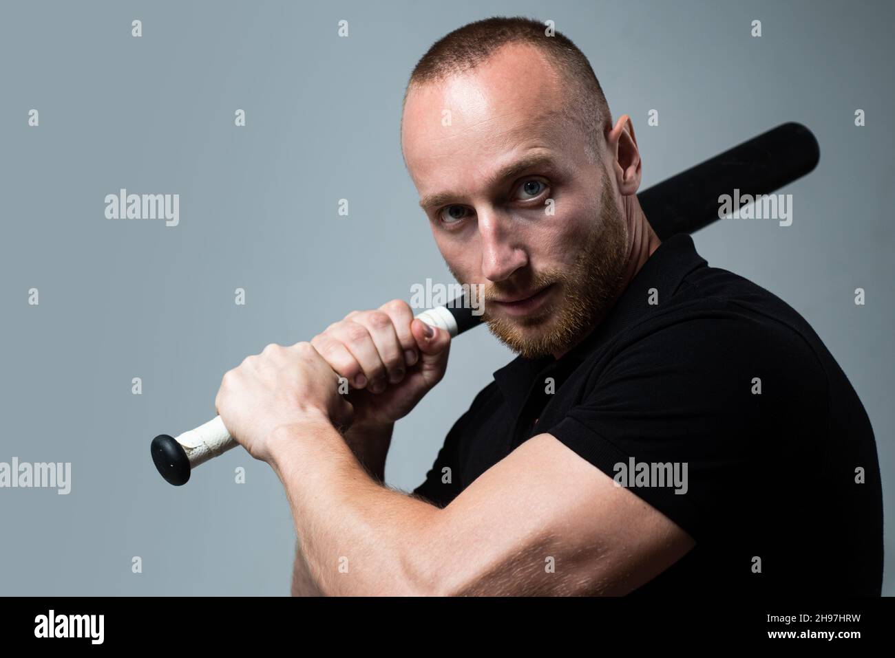 Guy with baseball bat for fighting. Dangerous man with serious emotion