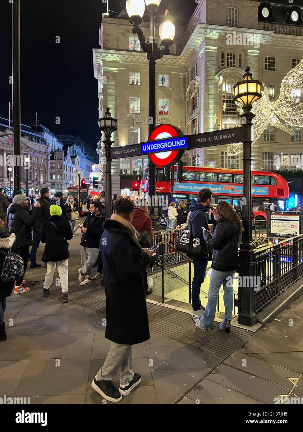 London, UK. 04th Dec, 2021. People stand in front of the Piccadilly Circus Underground Station on Dec. 4, 2021. The United Kingdom imposed new measures amid the Omicron COVID-19 variant. (Photo by Samuel Rigelhaupt ) Credit: Sipa USA/Alamy Live News Stock Photo