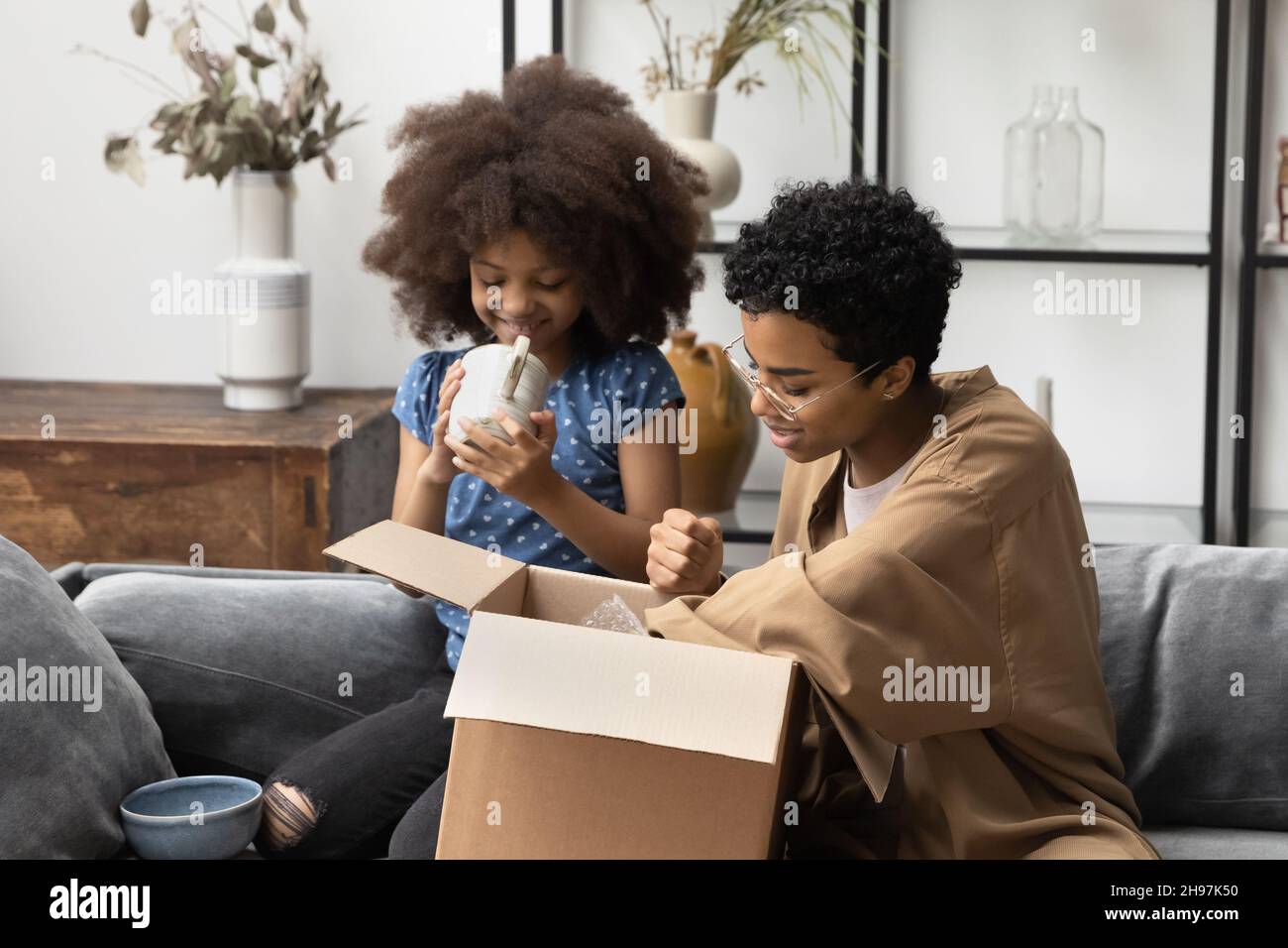 Happy African American family unpacking carton box. Stock Photo