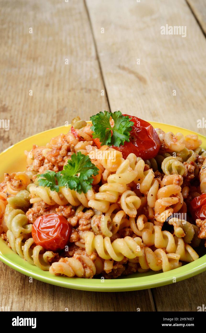 Pasta fusilli with bolognese tomato beef sauce on the kitchen table