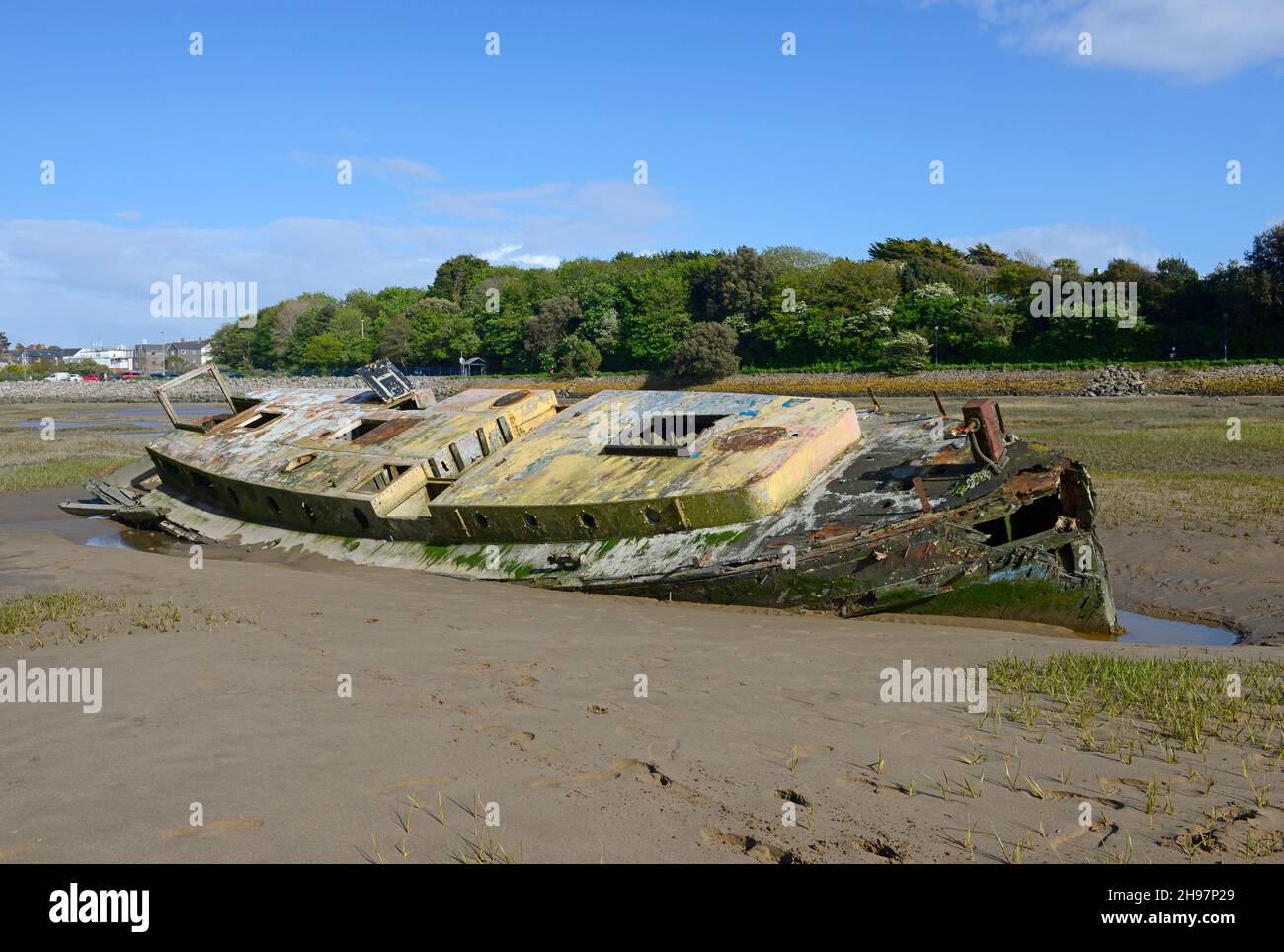A derelict boat lies beached in the harbour at Barry Island, Wales, UK Stock Photo