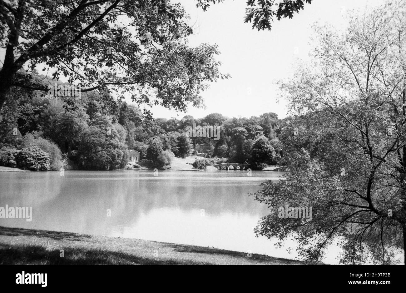Stourhead Garden, Stourton, Wiltshire, UK, showing the lake, C18th Palladian bridge, the Temple of Flora and the Bristol Cross. Black and white archive film photograph from 1990 Stock Photo